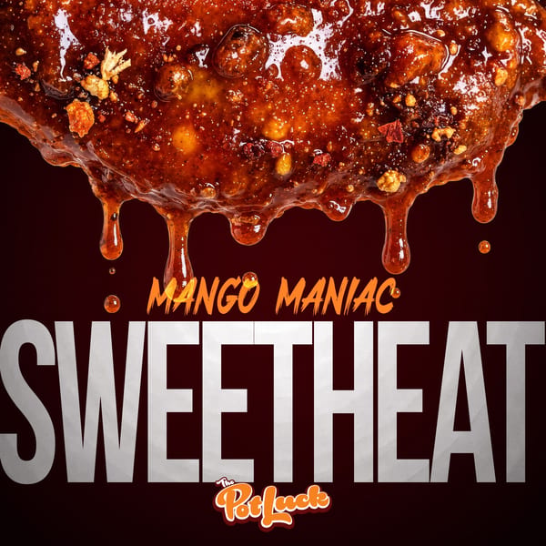 A close-up of a chicken wing dripping with mango maniac sweet heat sauce.