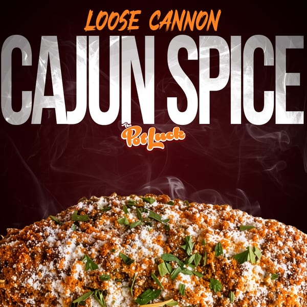 Close-up of a dish heavily seasoned with orange Cajun spice, white powder, and green herbs.
